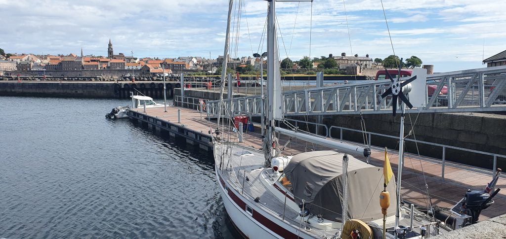 Sailing yacht tied up alongside pontoon with a gangway