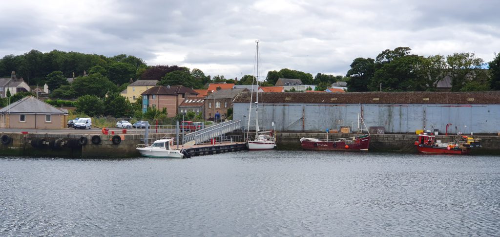 Two boats tied up alongside a pontoon with a walkway gangway