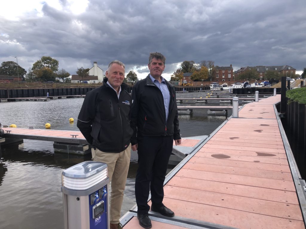 Two men standing on a terracotta coloured decked pontoon