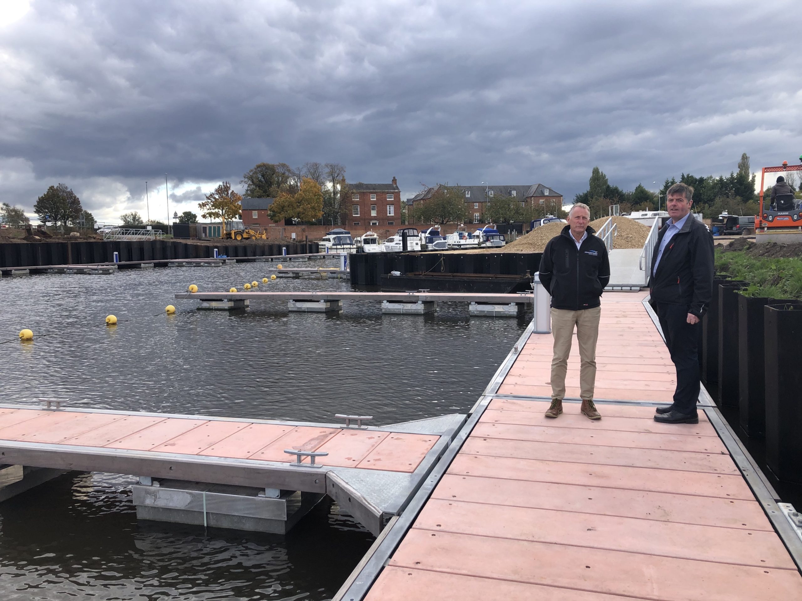 Two men standing on marina walkway pontoon