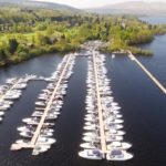 Three marina pontoons on Loch Lomond surrounded by green trees