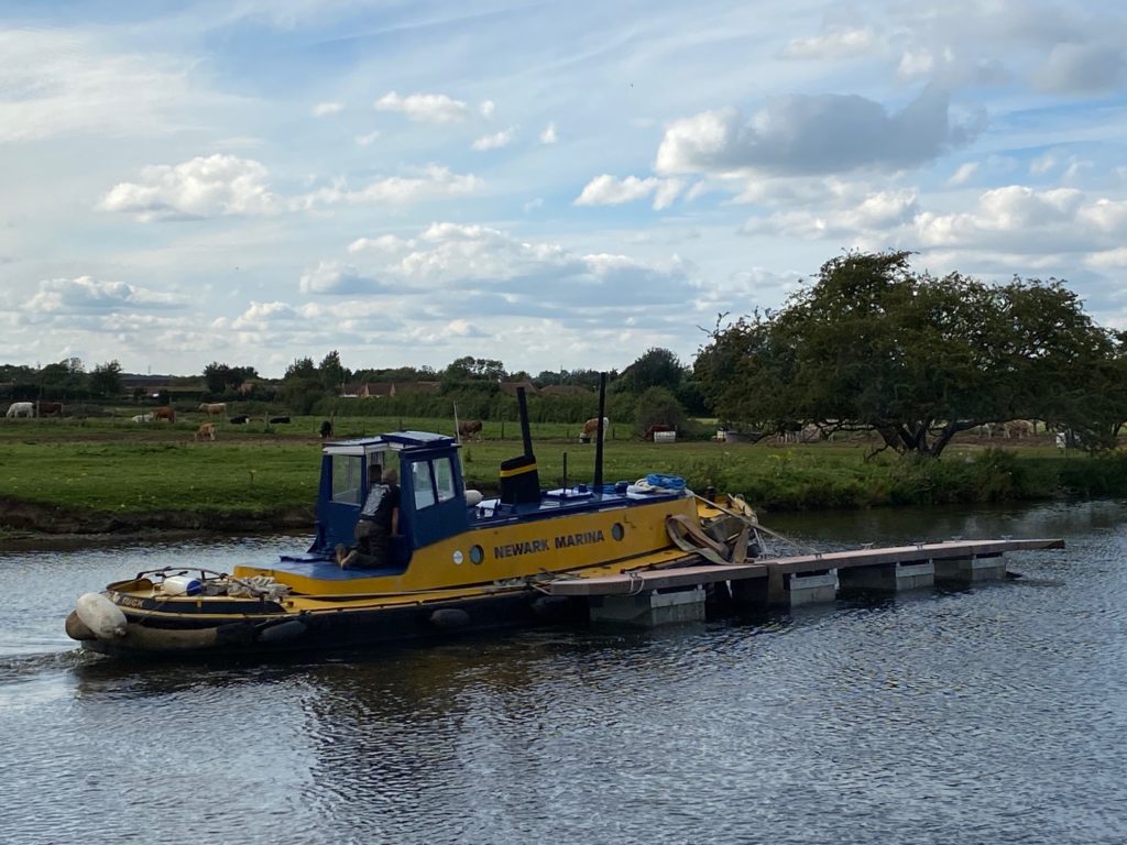 Workboat moving marina pontoon into position