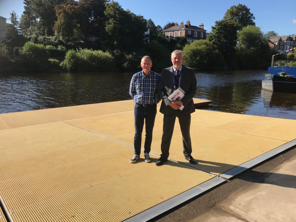Two men standing on a gap-minimesh deck rowing pontoon