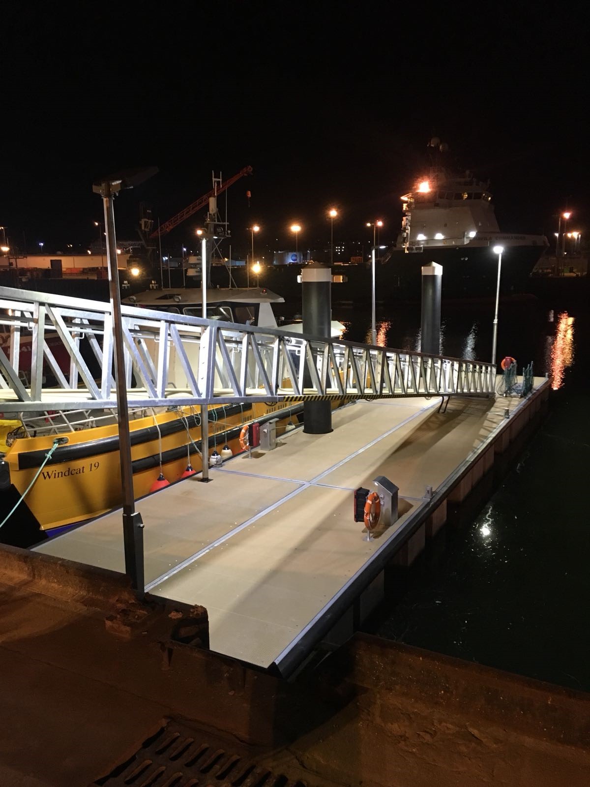 Heavy duty pontoon with crew transfer vessel alongside with gangway and overhead lighting