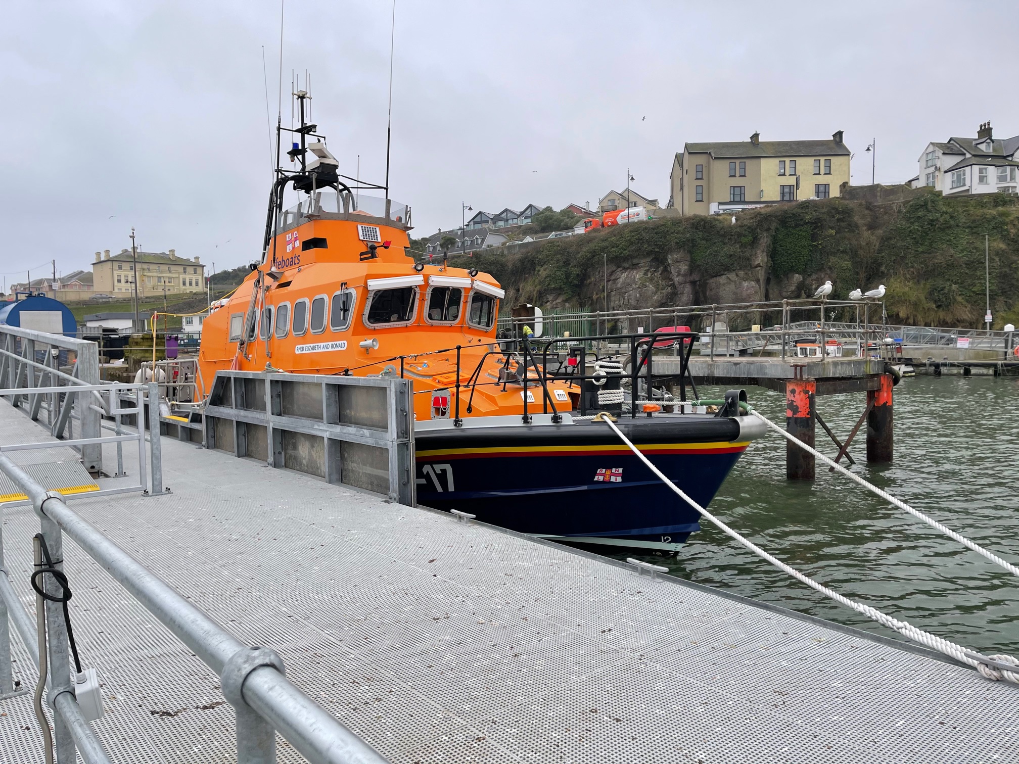 RNLU all-weather lifeboat tied alongside pontoon with guard rails