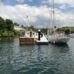 Grey GRC decked pontoon with two motorboats moored, one either side