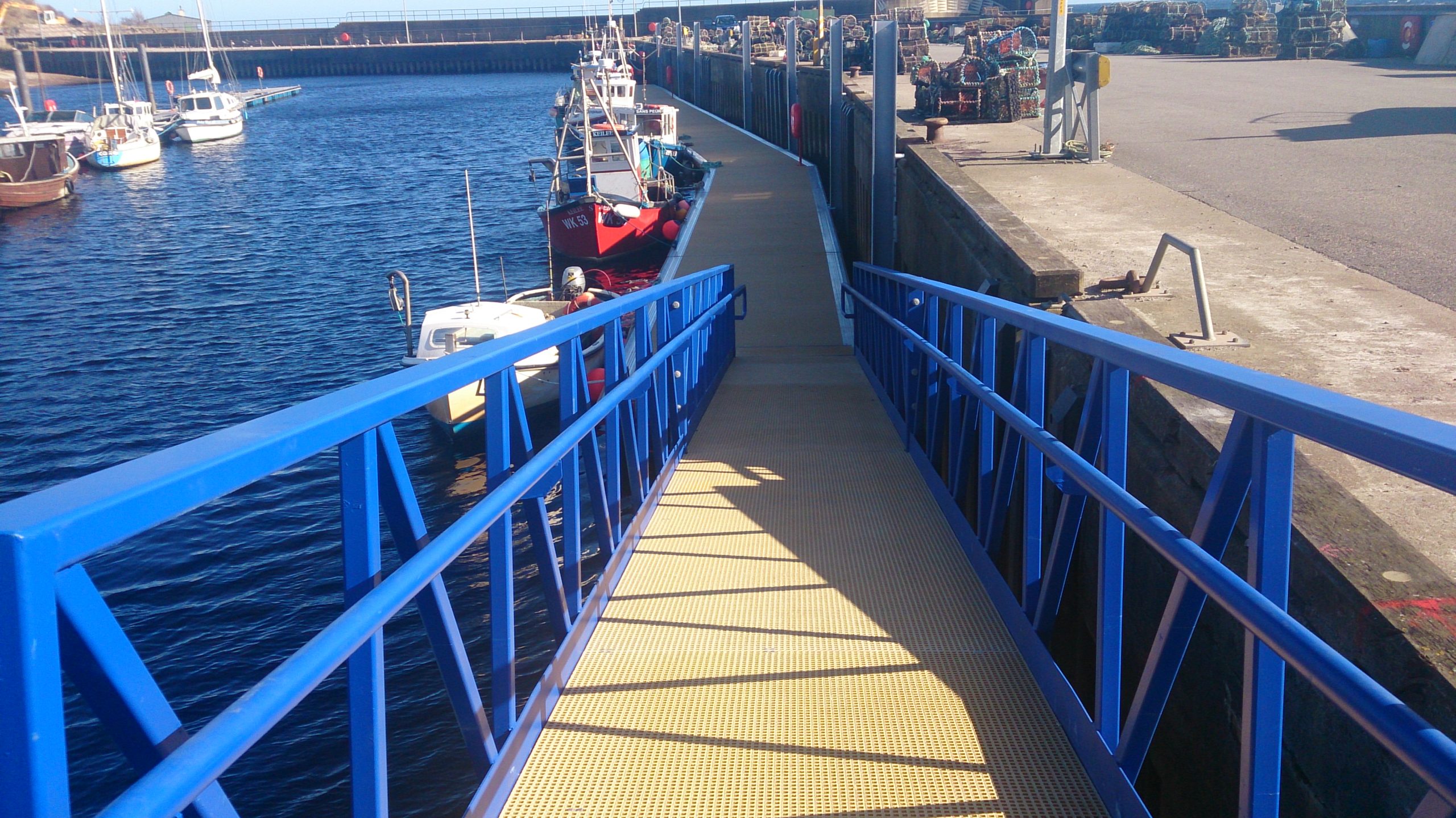 Gangway with blue railings leading down to a pontoon