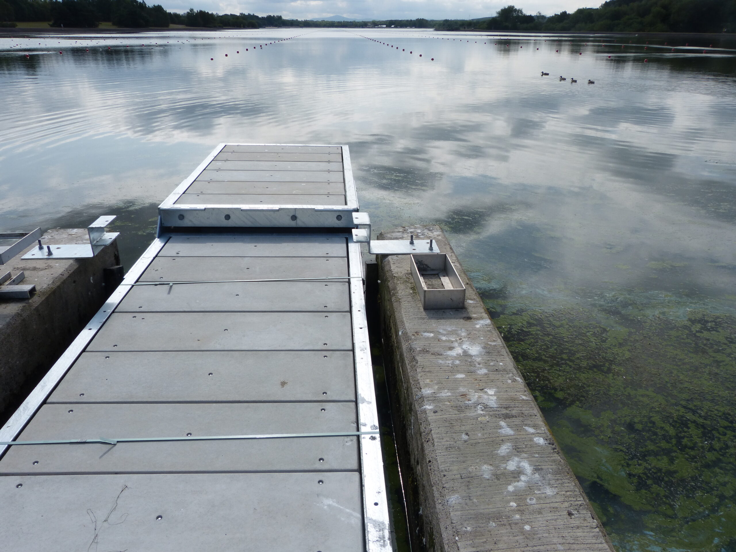 Rowing start pontoon with grey GRP decking on a calm body of water