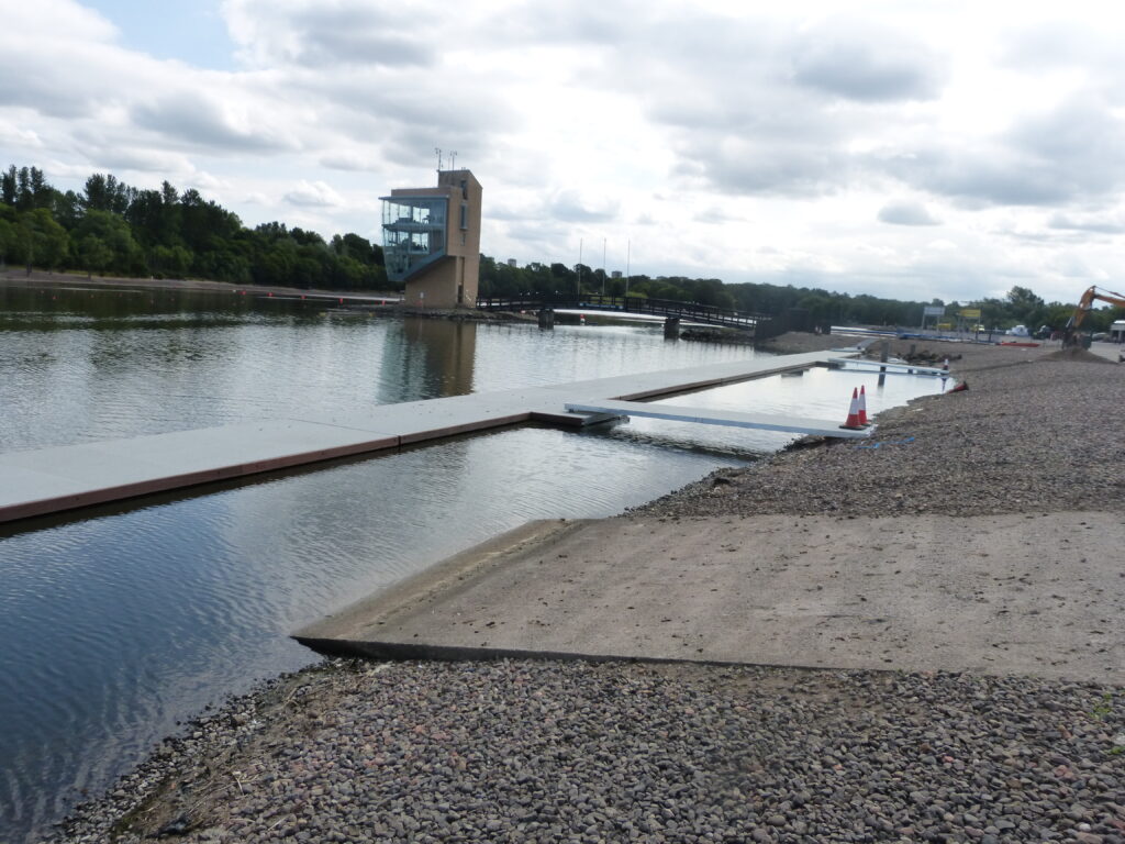 Gravel bank with a grey T shaped rowing pontoon attached