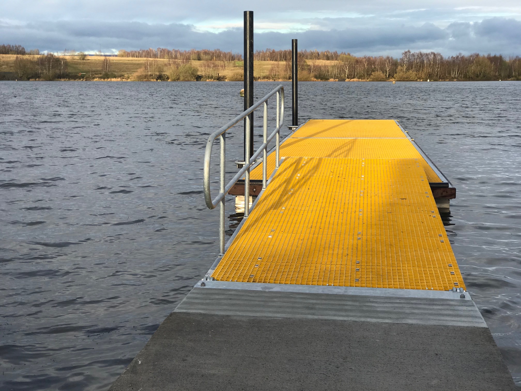 Yellow mini meshed GRP decked floating pontoon landscape view