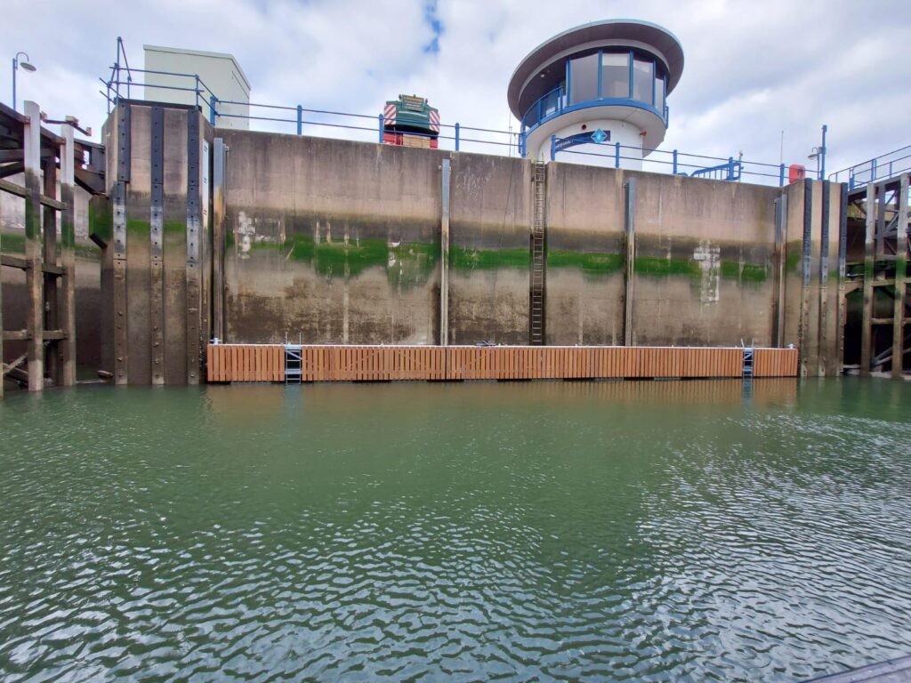 Side view of a long, thin lock pontoon with 1.1m high freeboard installed in the lock