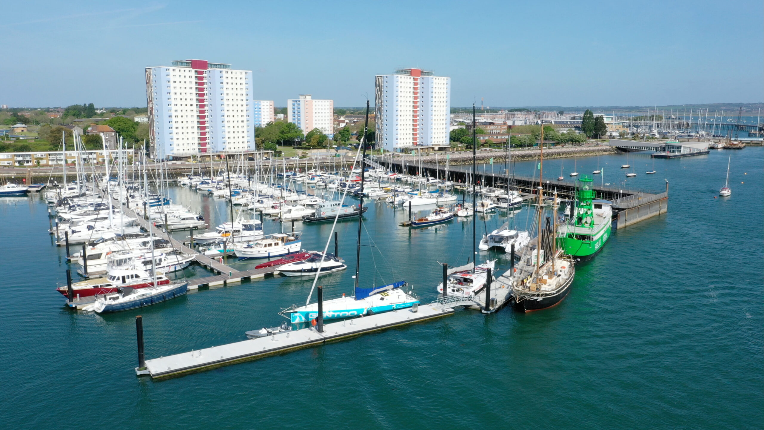 Aerial view of concrete pontoon with sail training vessel alongside