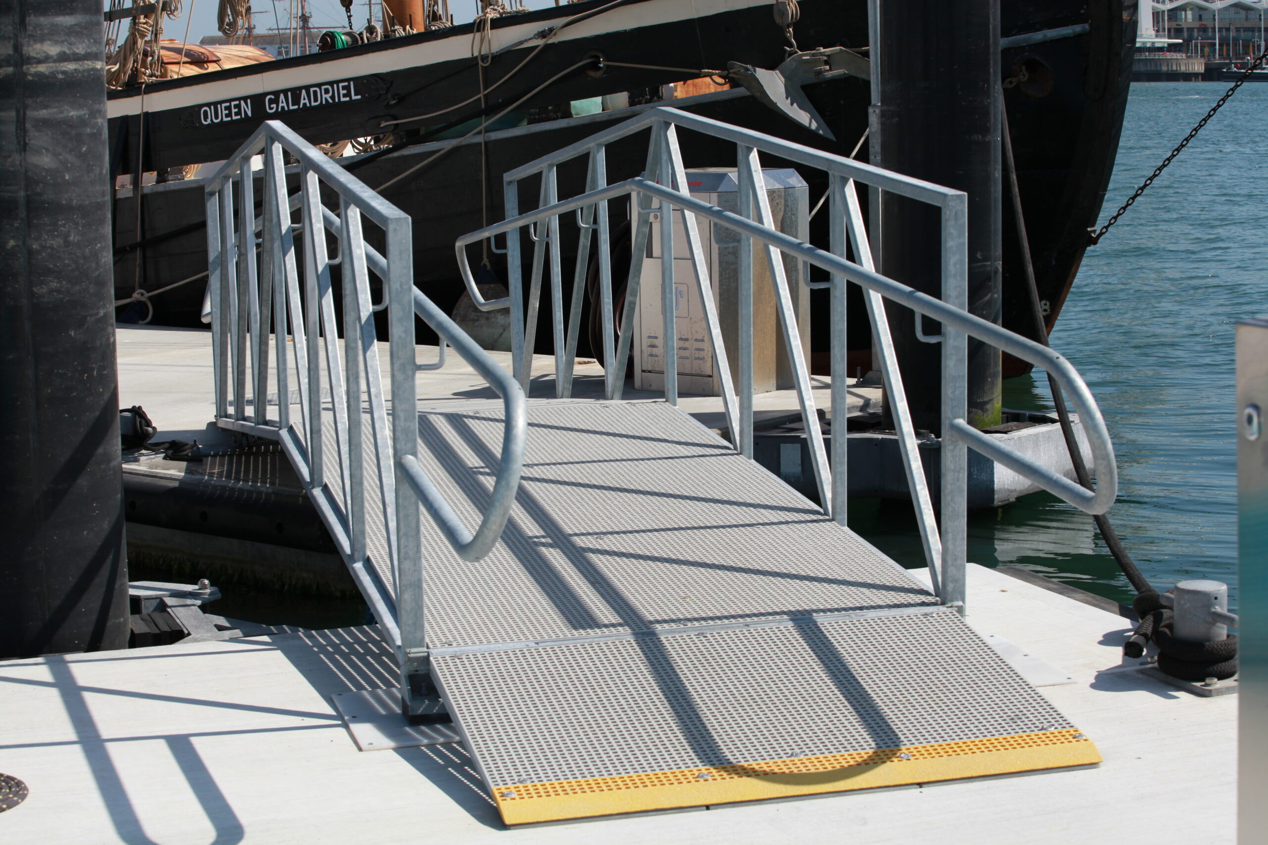 Metal gangway linking two sections of concrete pontoon