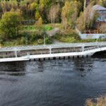 Bridge pontoon on river's edge with greenery in the background