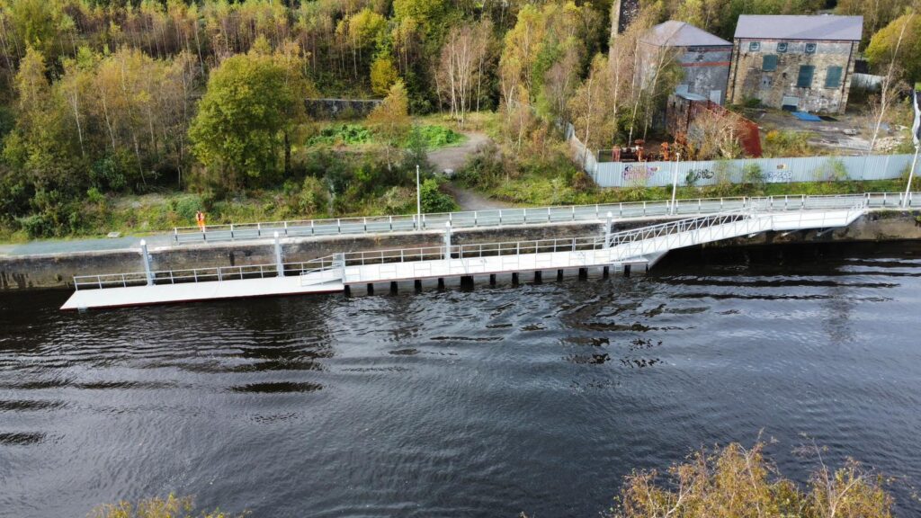 Long split level pontoon on quay wall with background of trees and bank