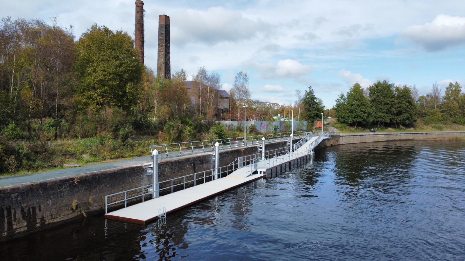 Long split level pontoon on quay wall with background of trees and bank