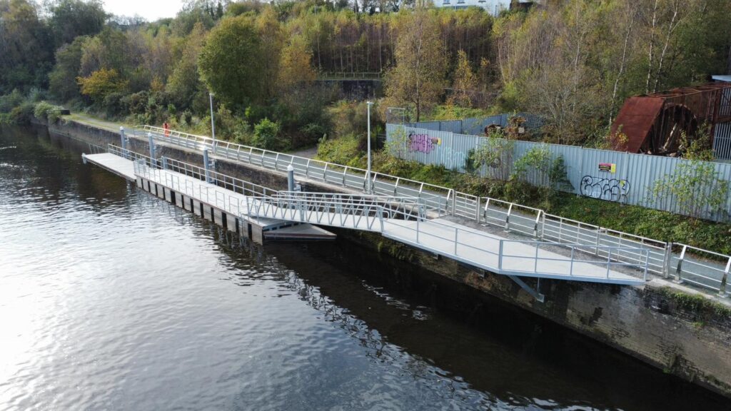 Long split level pontoon on quay wall with background of trees and bank