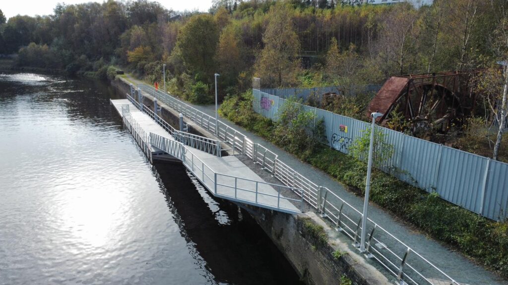 Long split level pontoon on quay wall with background of trees and bank