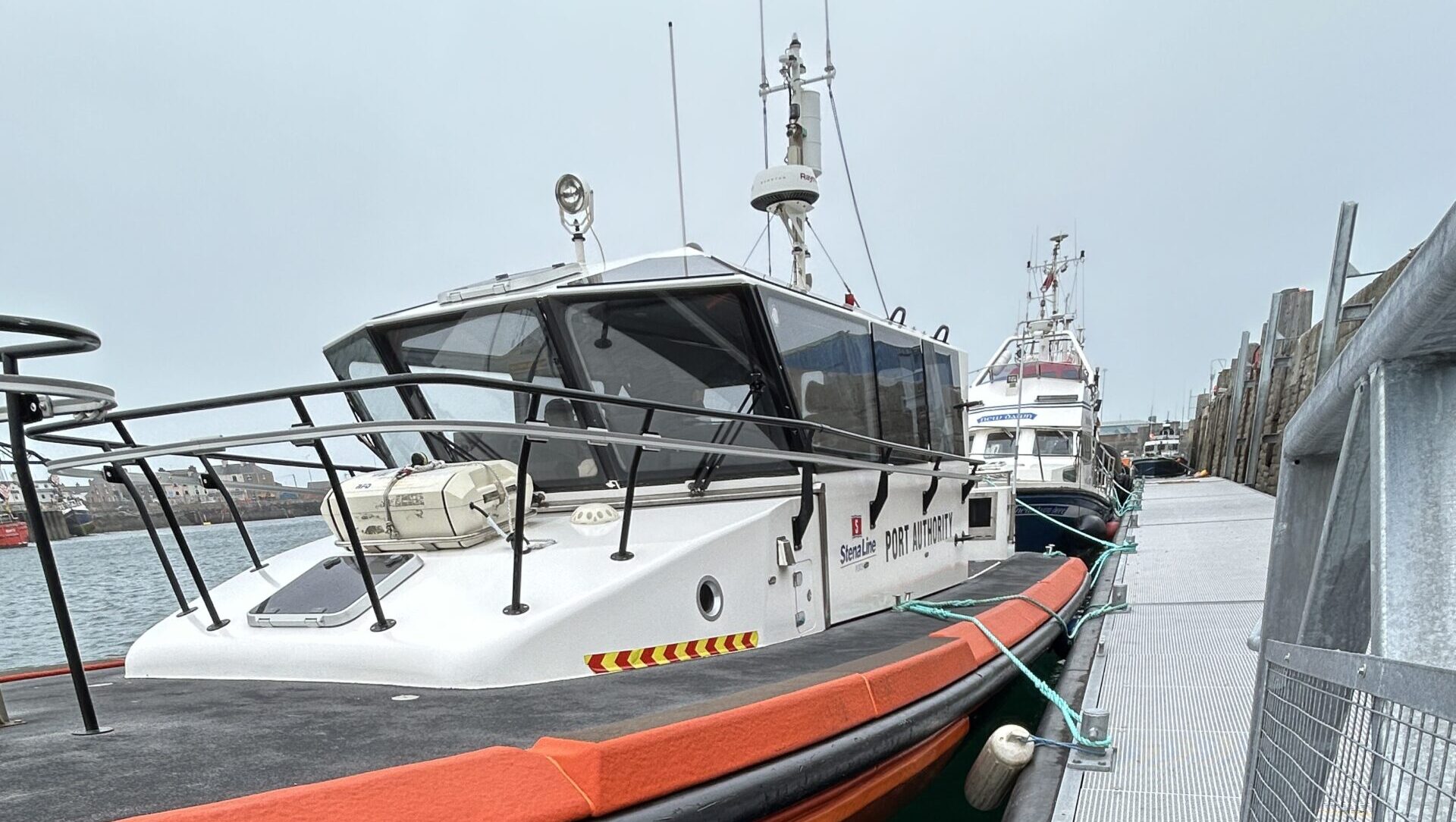 Tug sitting against new Inland and Coastal pontoon in the Port of Holyhead